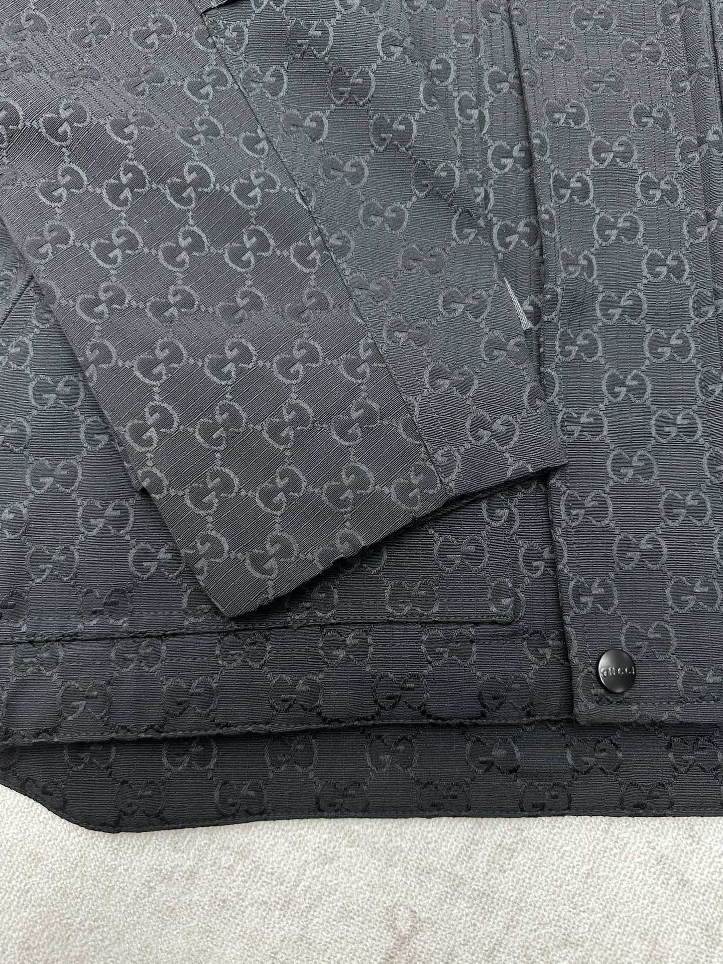 Gucci long jacket chest detail, dark GG pattern with flap pocket and snap strap