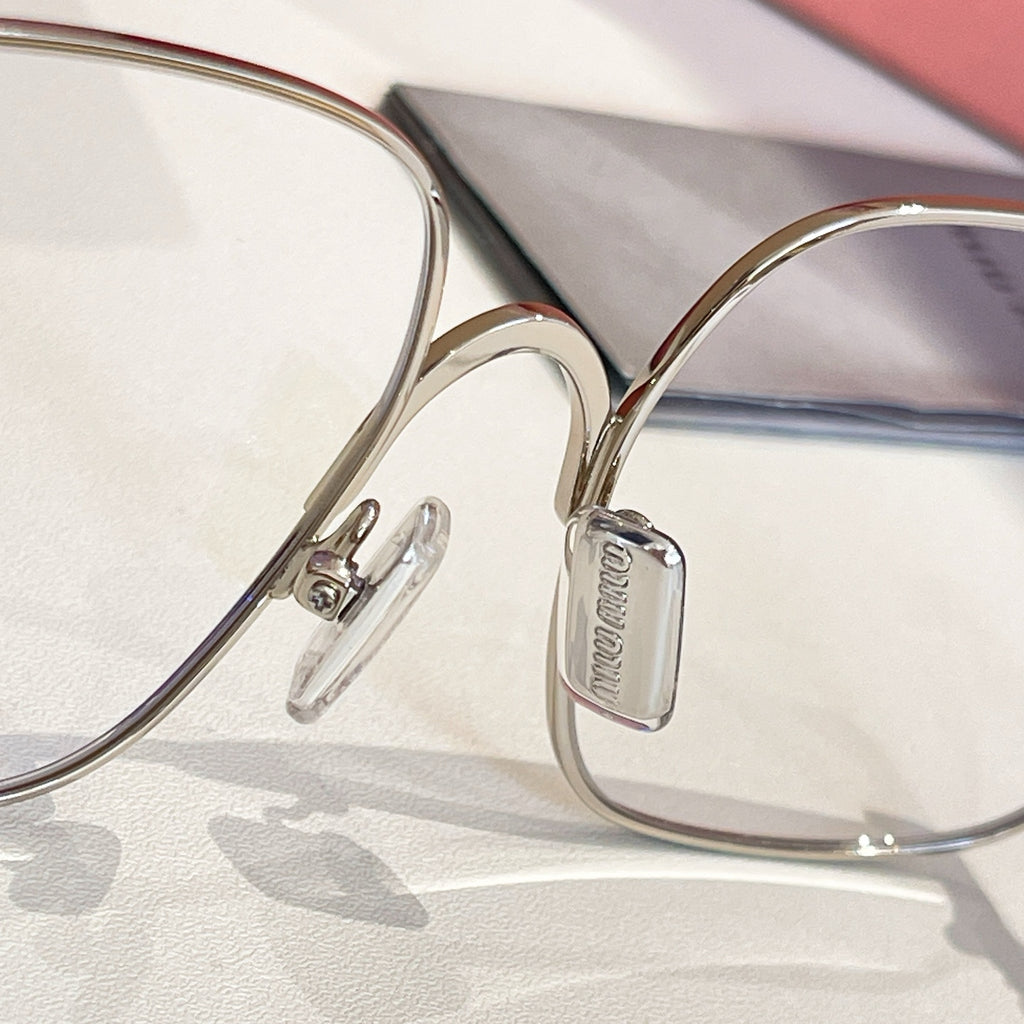 Silver eyeglass frame with clear temple tips and oval brand plate