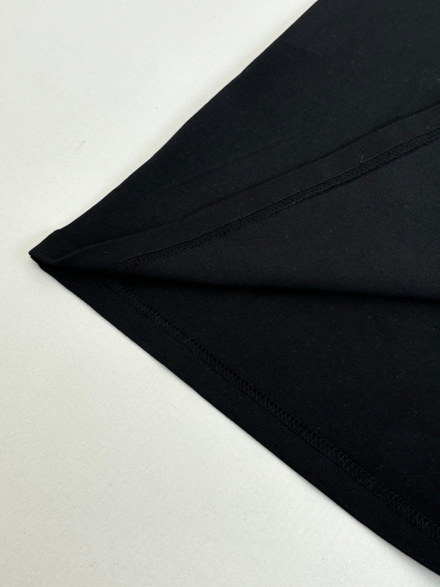 Louis Vuitton T-shirt sleeve and hem close-up in black with visible stitching.