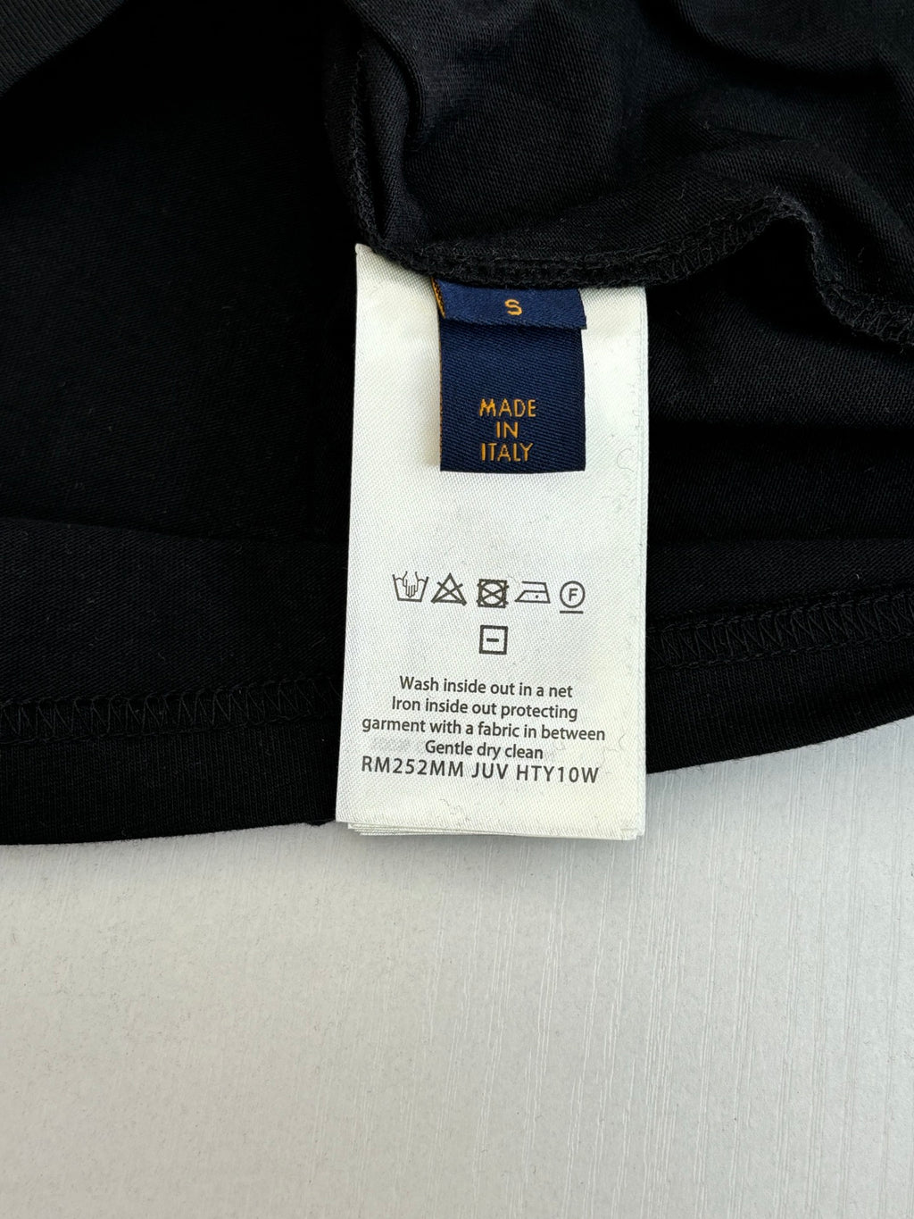 Louis Vuitton T-shirt care label close-up: Made in Italy and wash instructions.