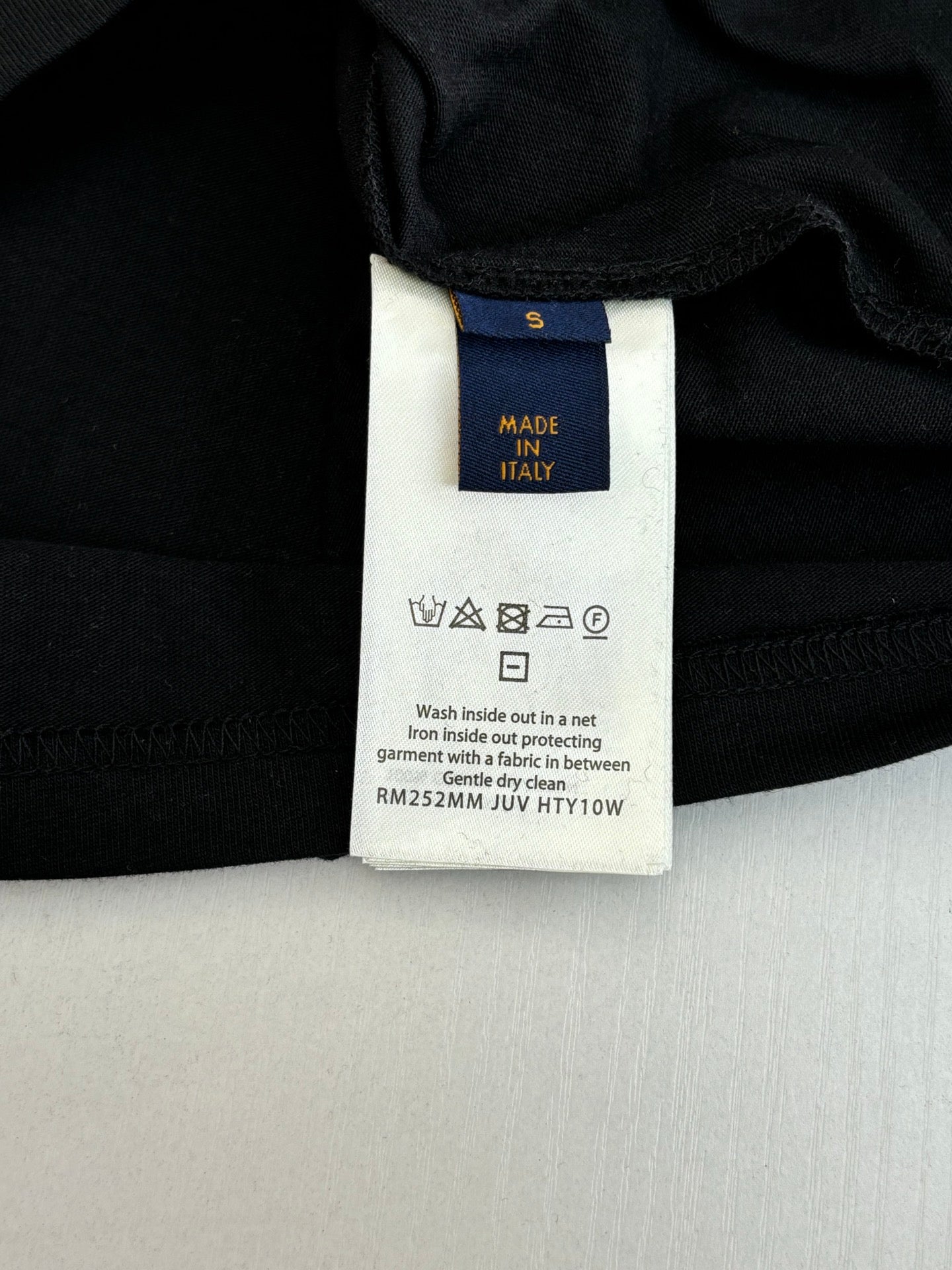 Louis Vuitton T-shirt care label close-up: Made in Italy and wash instructions.