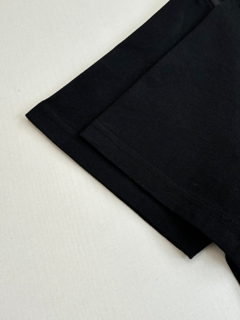 Louis Vuitton T-shirt lower side and hem close-up in black with stitched seam.