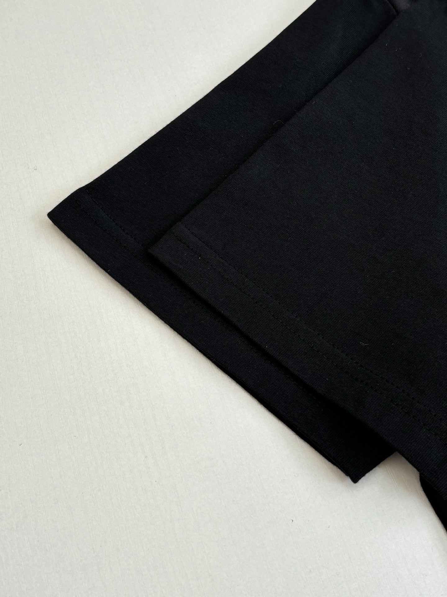 Louis Vuitton T-shirt lower side and hem close-up in black with stitched seam.