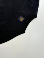 Louis Vuitton T-shirt sleeve close-up with small multicolor fabric patch label.