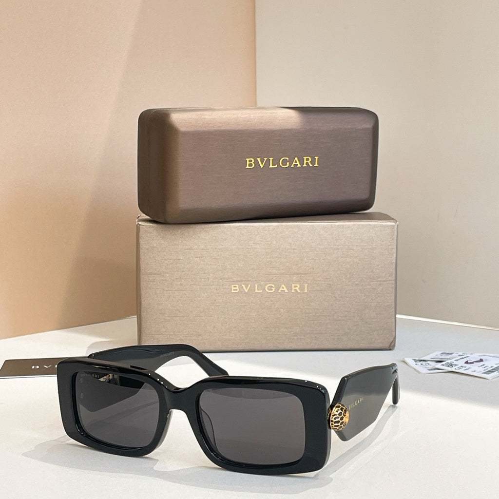 Black square sunglasses with dark lenses and gold logo charm on temple