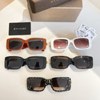 Assorted sunglasses: orange, white, black, and patterned frames with gold logo emblems