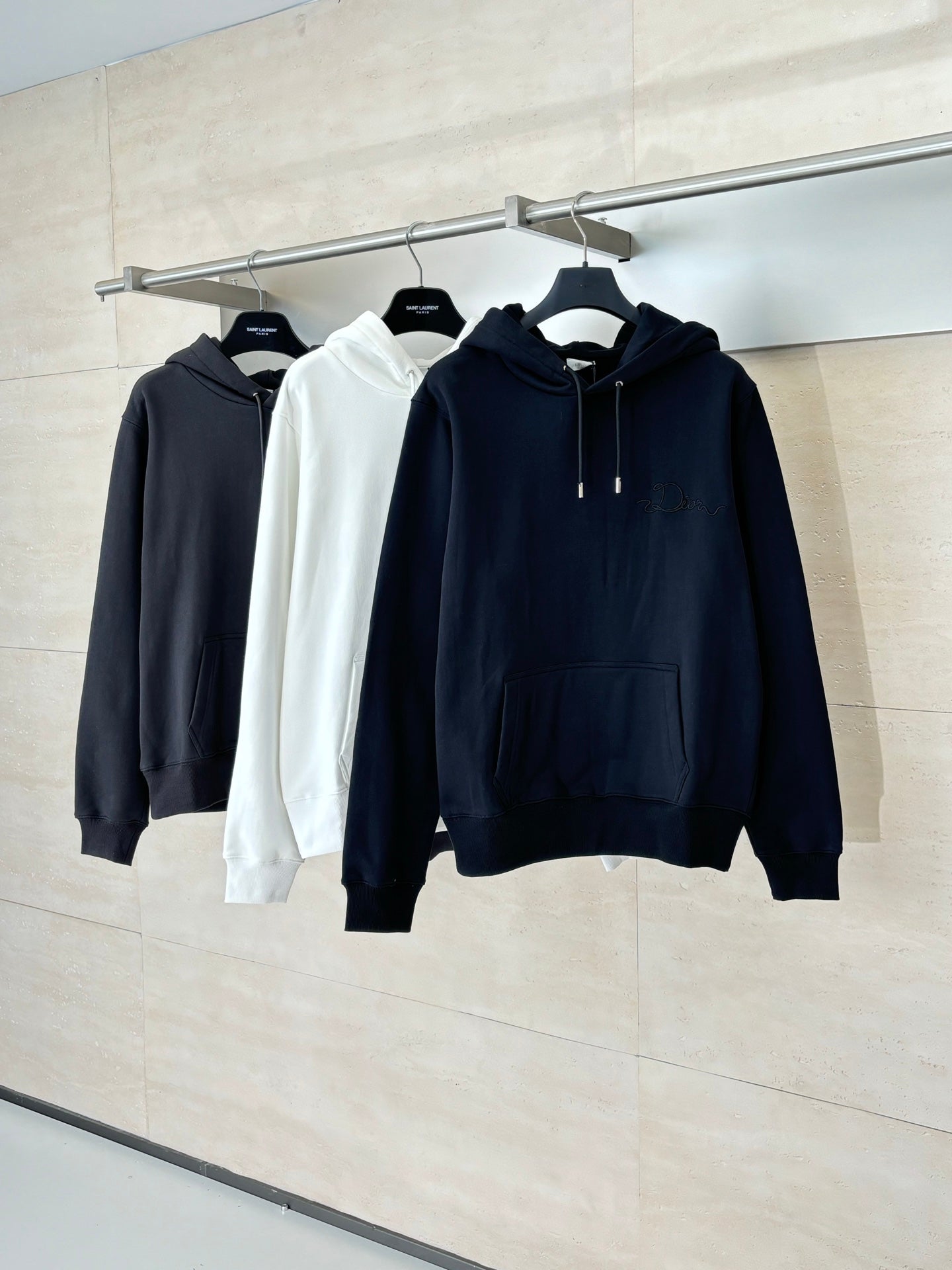 Dior hoodies on hangers: dark navy, white, and dark blue