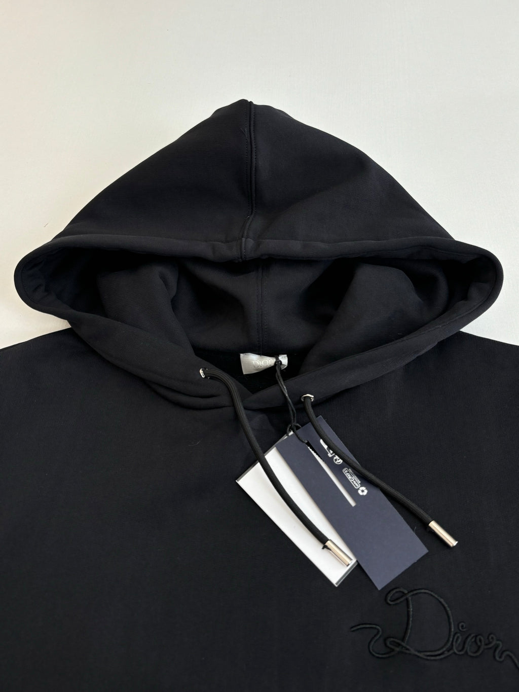 Dior hoodie in black with hood and drawstrings, embroidered Dior script on chest