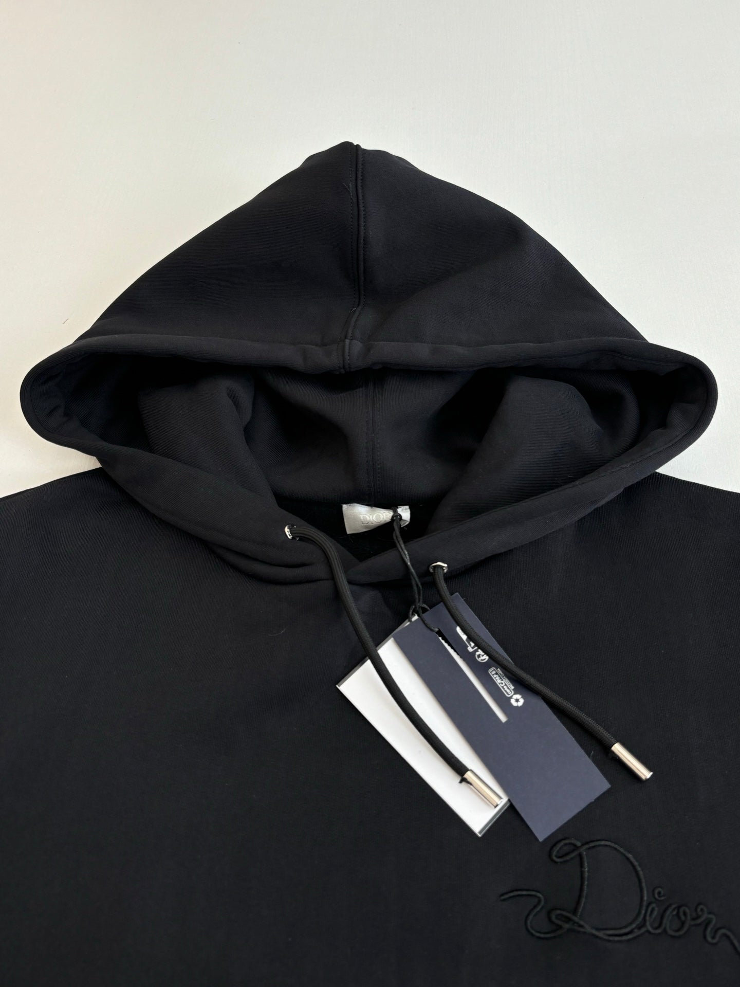 Dior hoodie in black with hood and drawstrings, embroidered Dior script on chest