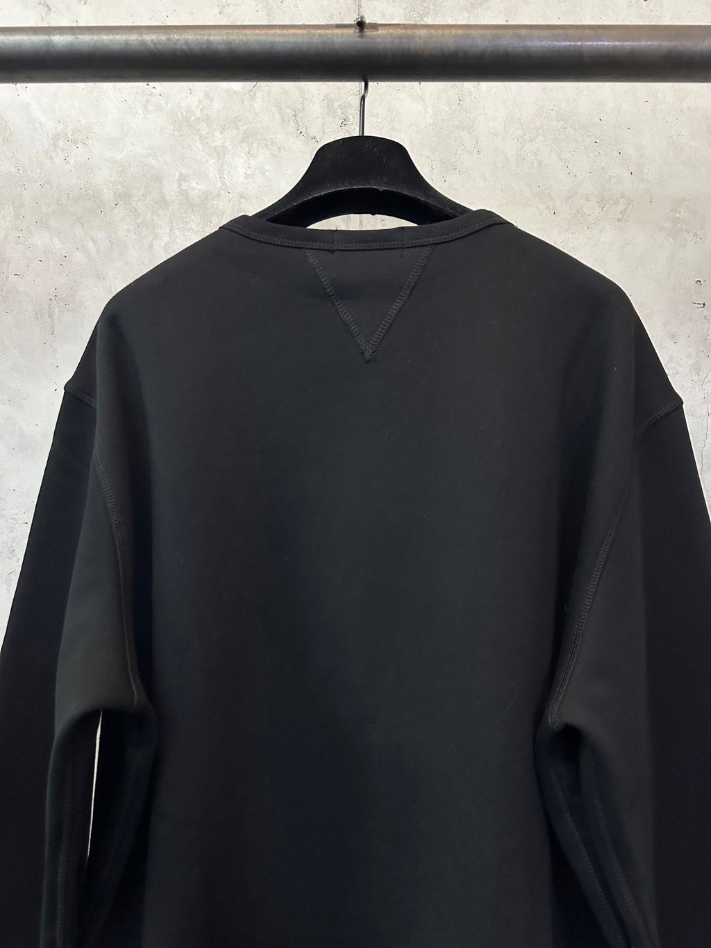 Black crewneck sweatshirt back view with diagonal shoulder seam