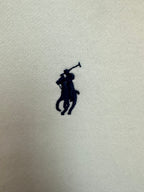 Small embroidered navy Polo player logo on white fabric