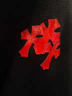 Red cross applique on a black long-sleeve shirt