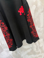 Black long-sleeve shirt with red patterned sleeve and red cross accent