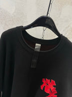 Black long-sleeve shirt with crew neck and red cross chest applique
