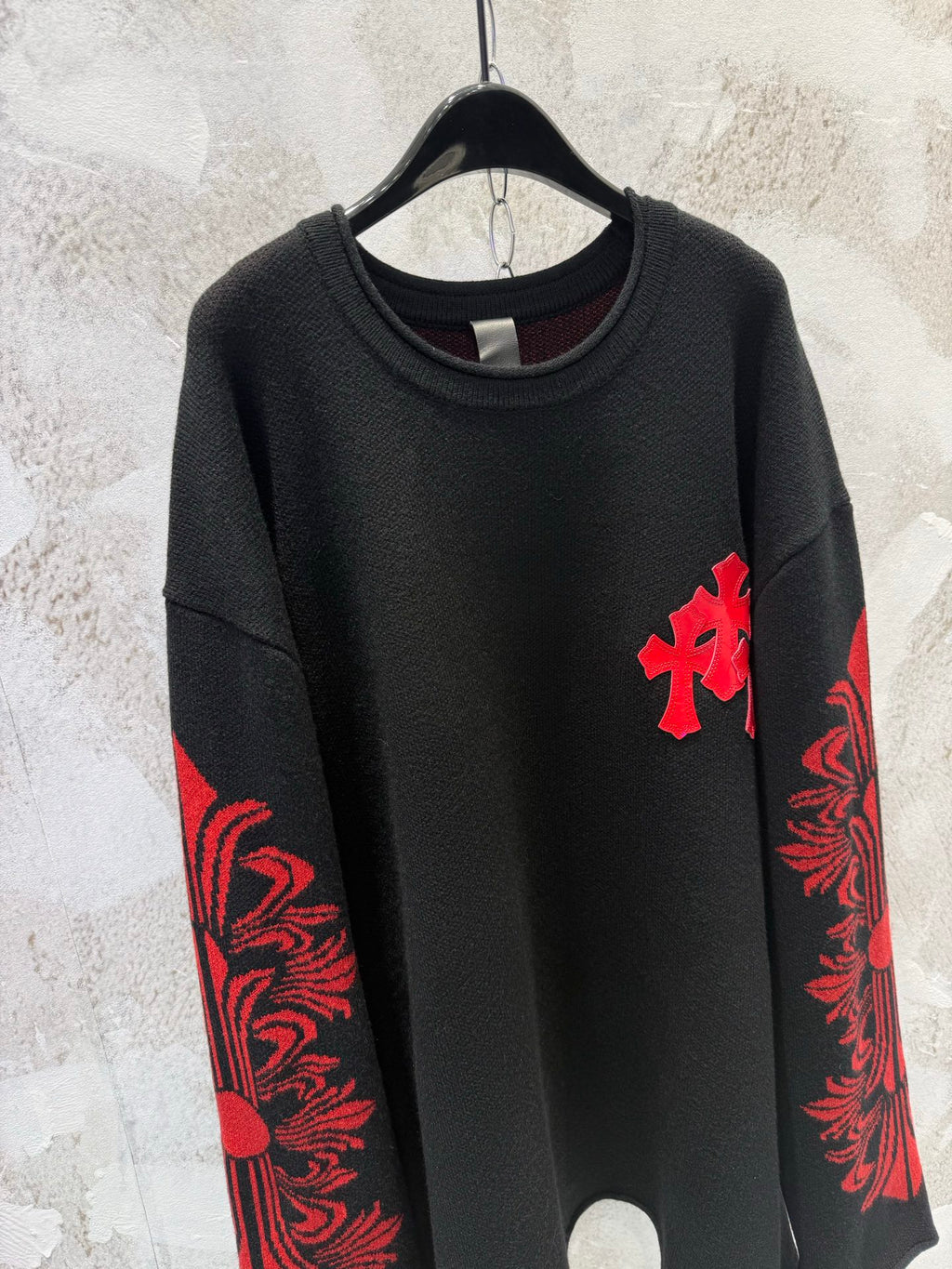Black long-sleeve shirt with red cross chest detail and red sleeve design