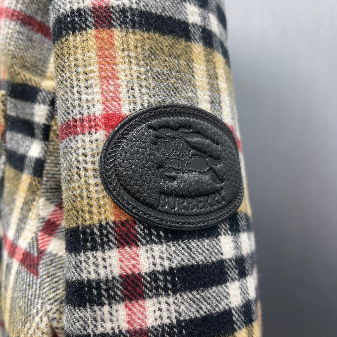 Burberry plaid fabric with oval leather logo patch and button accents