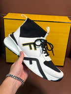 White and black high-top sneaker with ribbed black ankle cuff and logo patch
