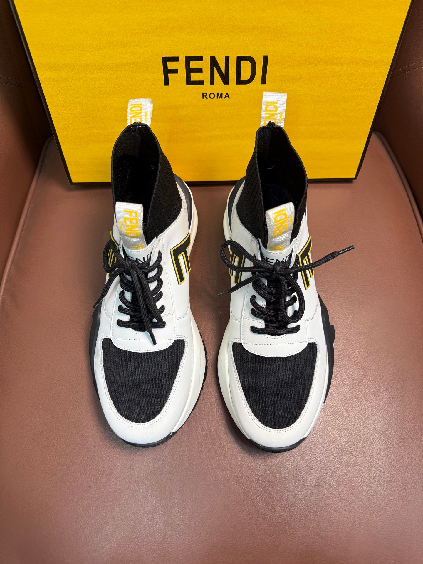 White and black high-top sneakers with black laces and contrast logo panels