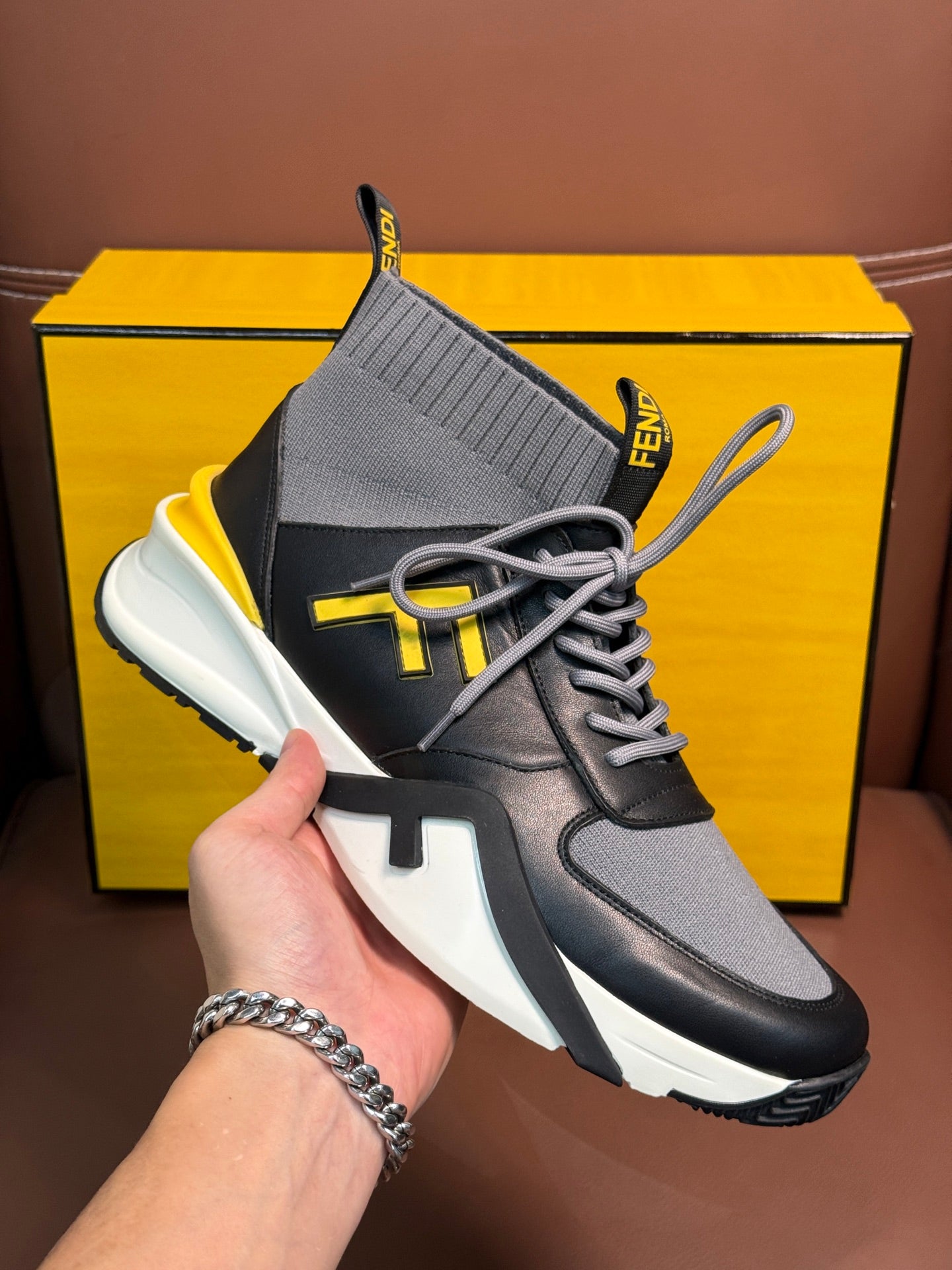 Fendi unisex high-top sneaker with knit collar, gray laces, white outsole, yellow logo
