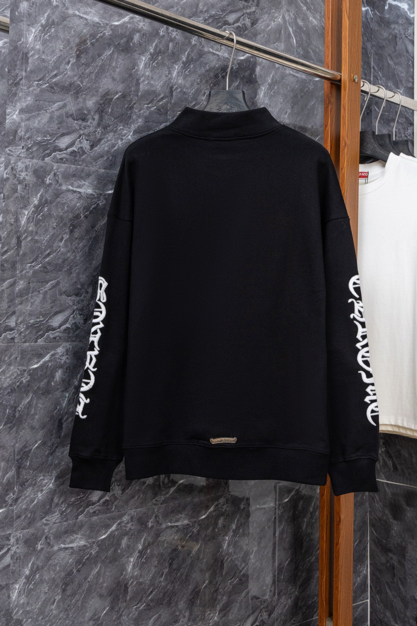 Black zip-up hoodie, back view, white sleeve graphic