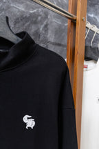 Black hoodie close-up of collar with small white chest logo