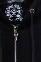 Black hoodie zipper close-up with decorative emblem on chest