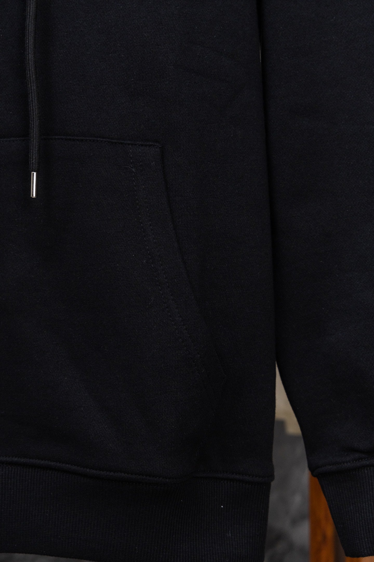 Black hoodie sleeve and side pocket with ribbed cuff