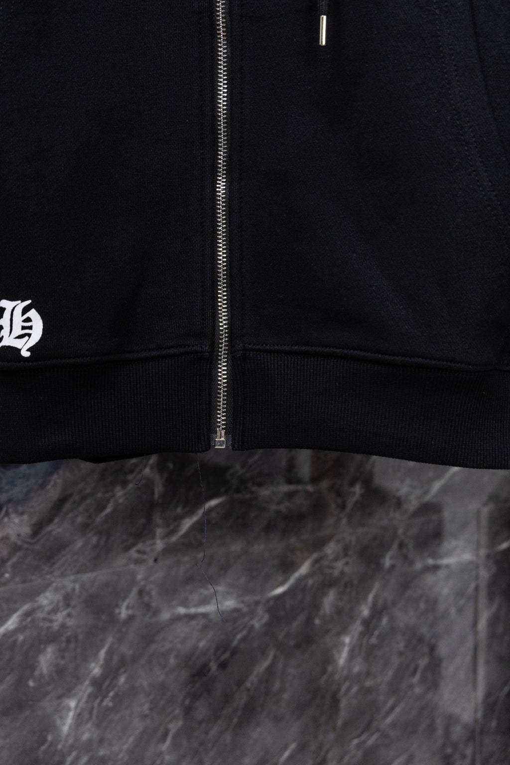 Black hoodie front zipper with ribbed hem and drawstring area
