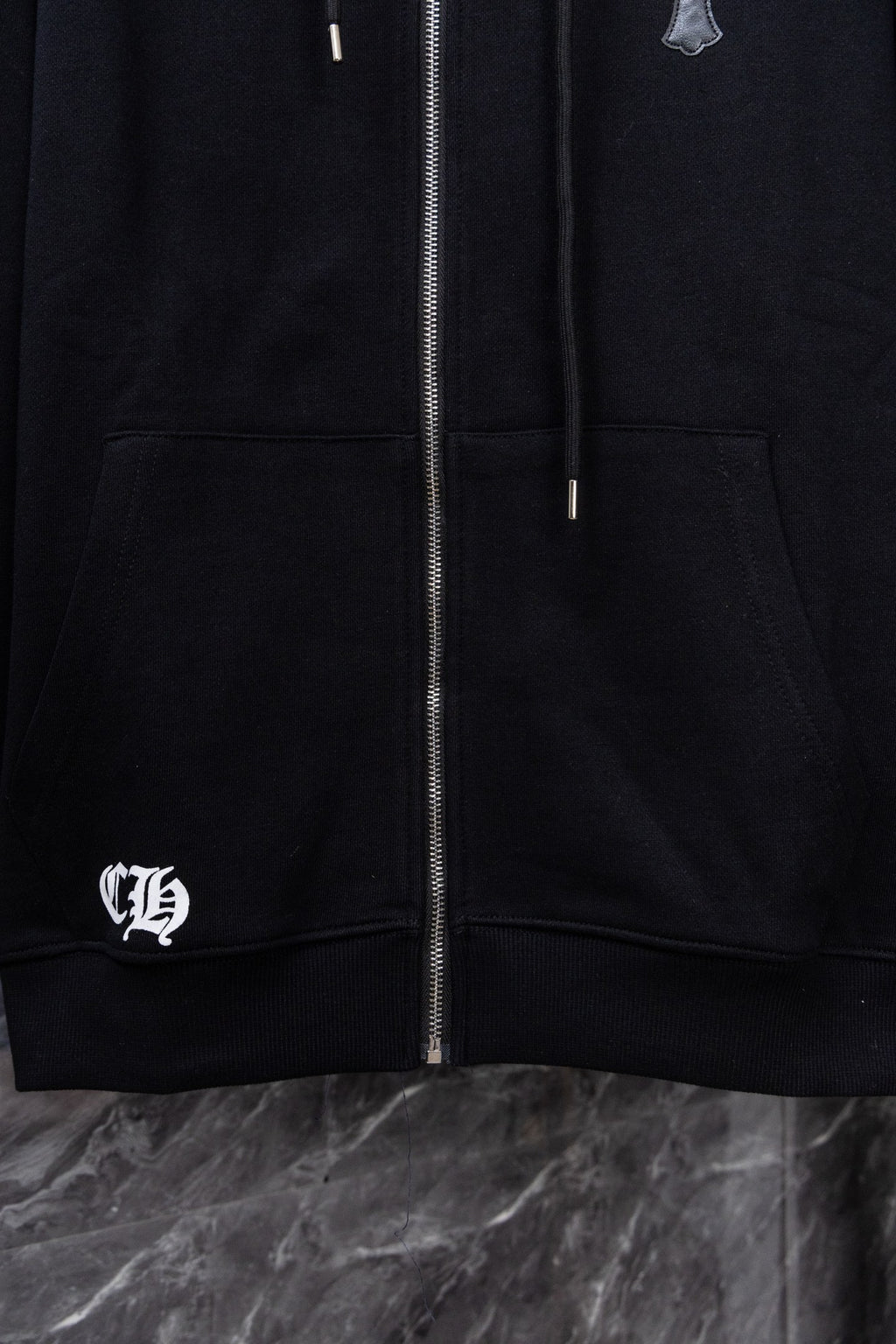 Black zip-up hoodie with front zipper, kangaroo pocket, and left chest logo