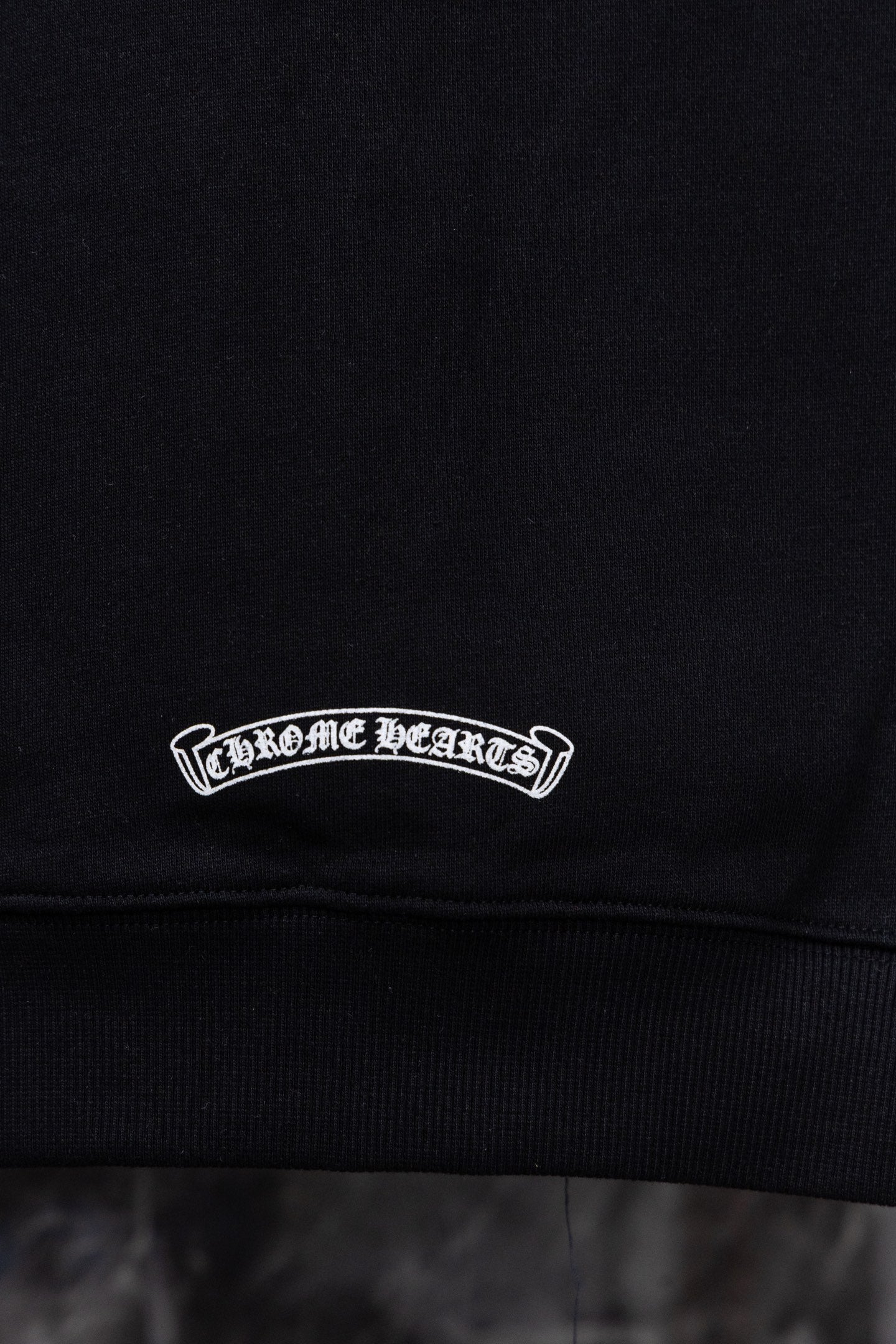 Black hoodie with white oval logo embroidery on chest
