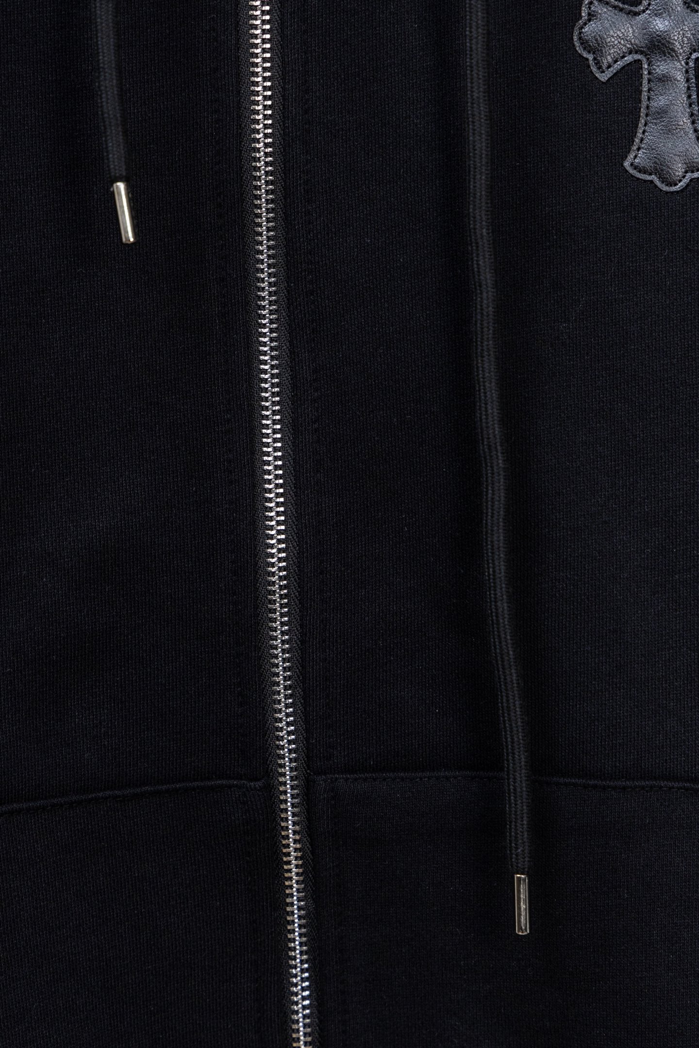 Dark zip-up hoodie front with silver zipper