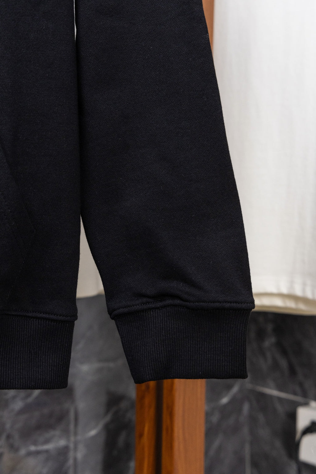 Dark zip-up hoodie sleeve cuff with ribbed trim