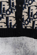 Knit cardigan front with black ribbed hem and navy/cream geometric jacquard