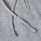 Light gray hoodie fabric with drawstring cords at the hood opening