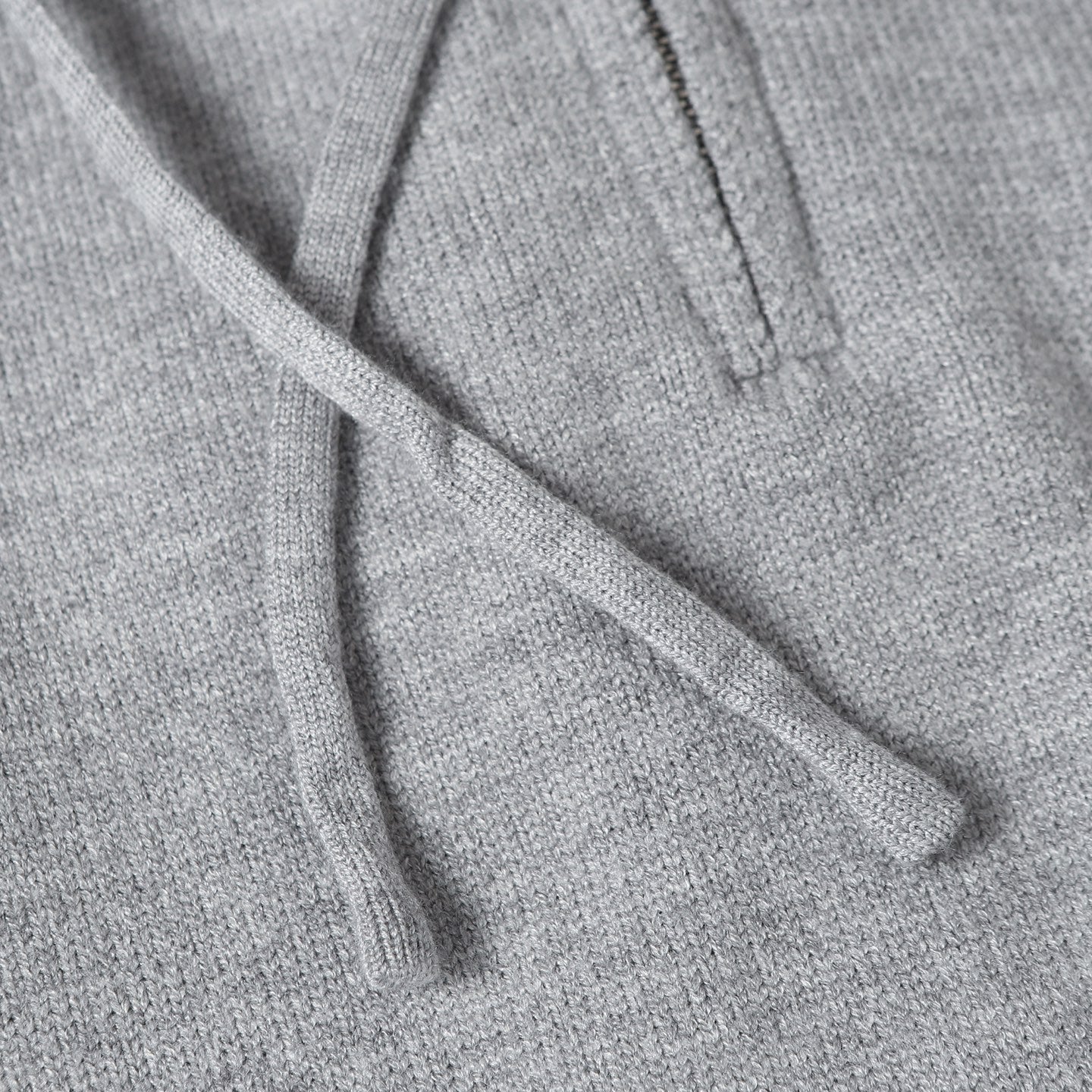 Light gray hoodie fabric with drawstring cords at the hood opening
