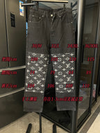 Dark denim pants with white monogram print band at the hems and straight legs