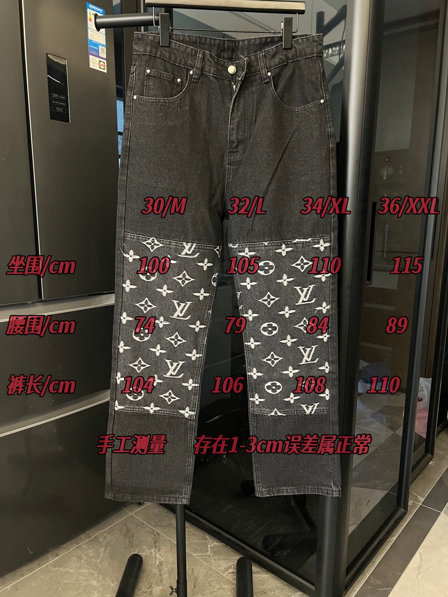 Dark denim pants with white monogram print band at the hems and straight legs