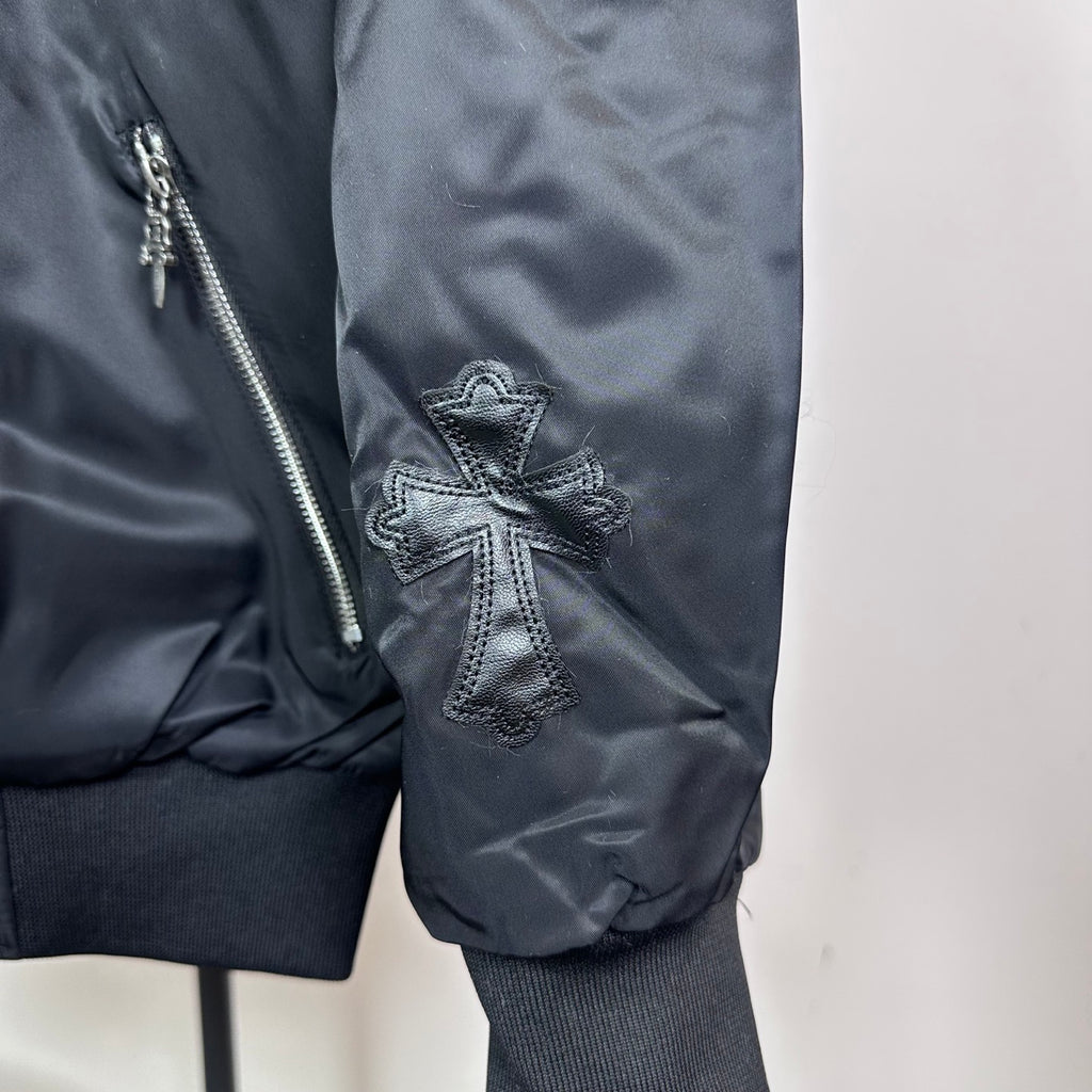 Dark blue bomber jacket side pocket with zipper and cross stitched patch on sleeve