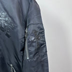 Dark blue bomber jacket sleeve with side zipper pocket and cross applique