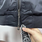 Dark blue bomber jacket close-up of zipper pull and small hanging tag