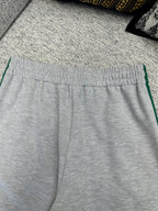 Gray Gucci track pants with elastic waistband and green side stripe trim