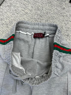 Gray Gucci pants with elastic waistband, drawstring, and red/green web stripe