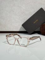 Prada eyeglass frames with light pink tortoiseshell acetate and clear lenses, logo on lens.