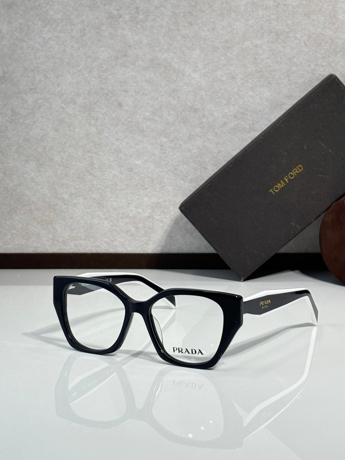 Prada eyeglass frames with dark blue-black acetate front and clear lenses, logo on temple.