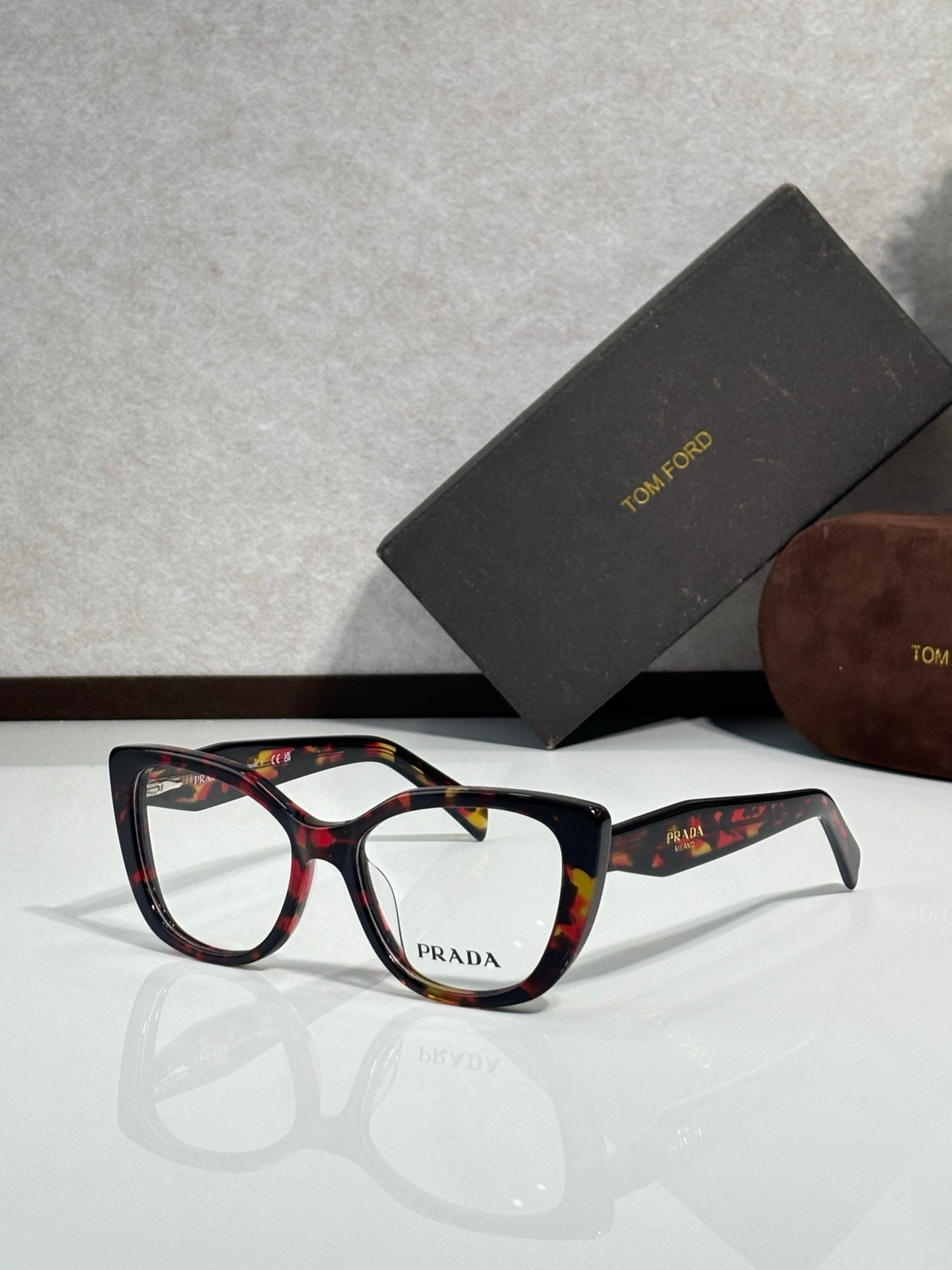 Prada eyeglasses, black rectangular frames with multicolor temples and Prada logo on front