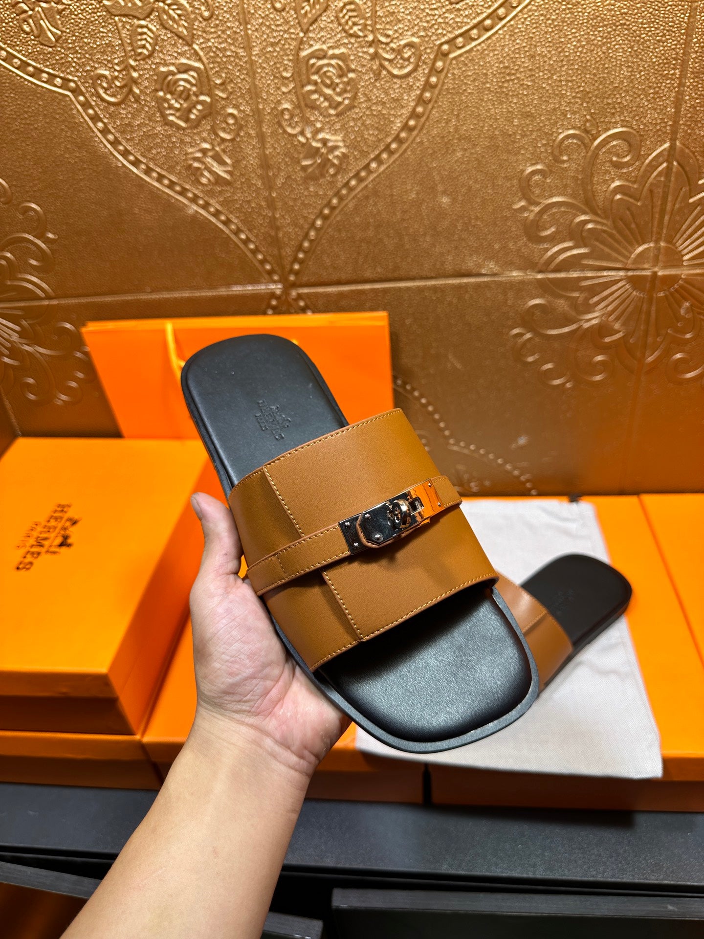 Tan leather slide sandal with silver buckle strap and dark footbed