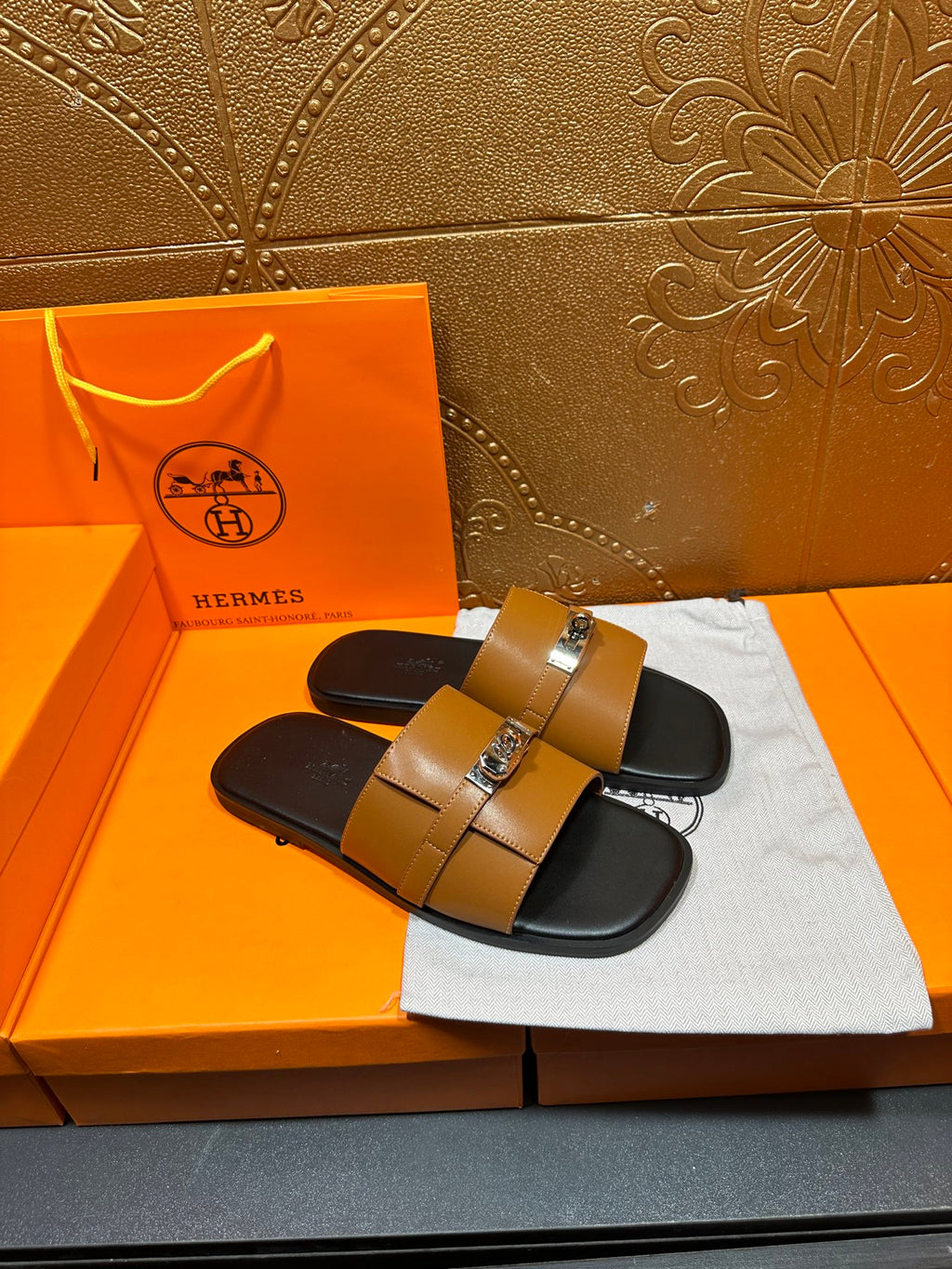 Tan leather slide sandals with double straps and silver buckle detail