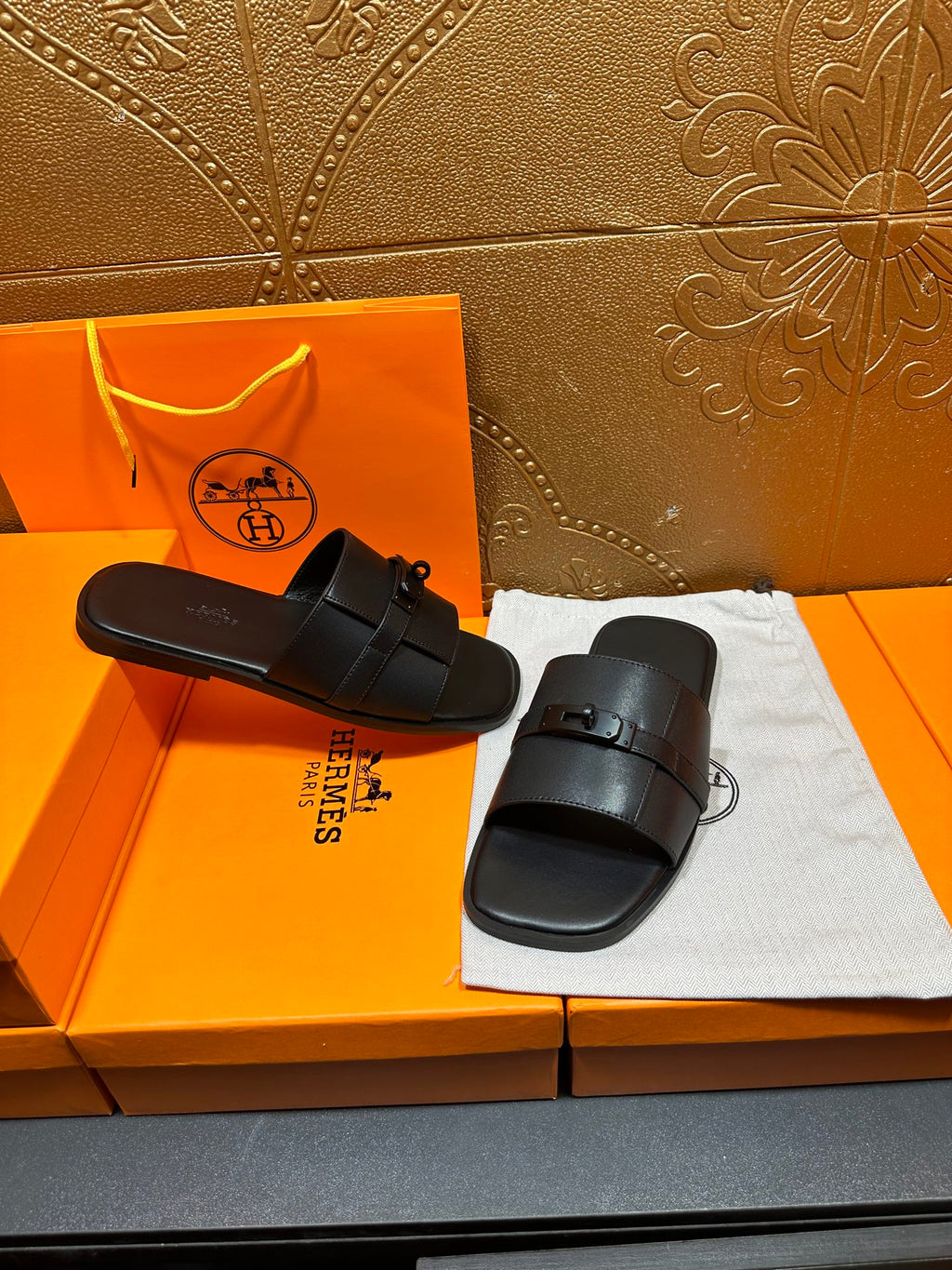 Hermes black leather slide sandals with wide straps and metal buckle detail