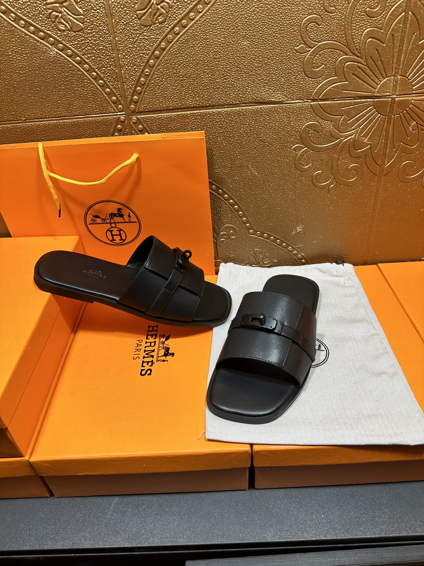 Hermes black leather slide sandals with wide straps and metal buckle detail
