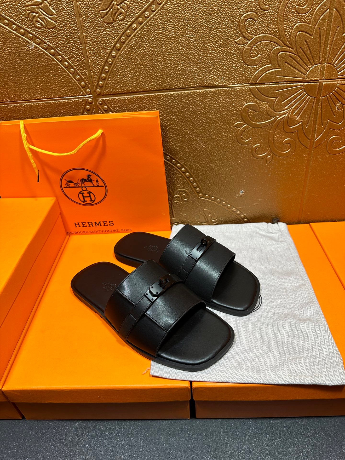 Hermes black leather slide sandals shown from above with wide buckle strap